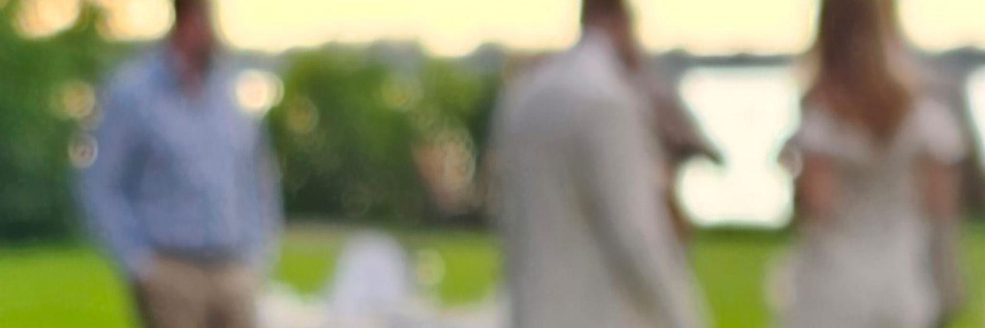 Unscharfes Foto von Gästen im Schlossgarten Golm bei Potsdam, im Hintergrund der Zernsee im warmen Abendlicht einer Sommerhochzeit.